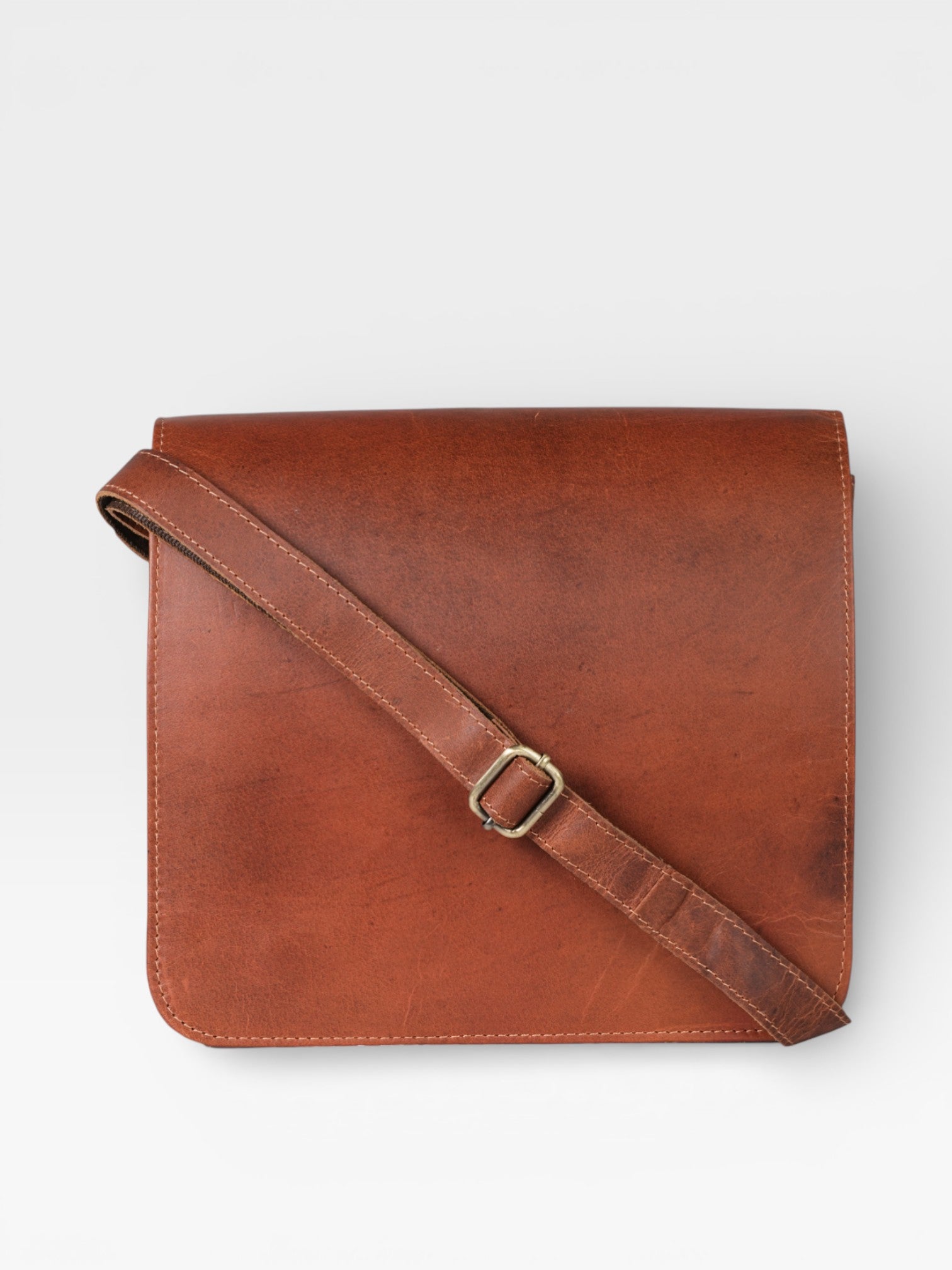 Brown leather bag with a strap on a white background