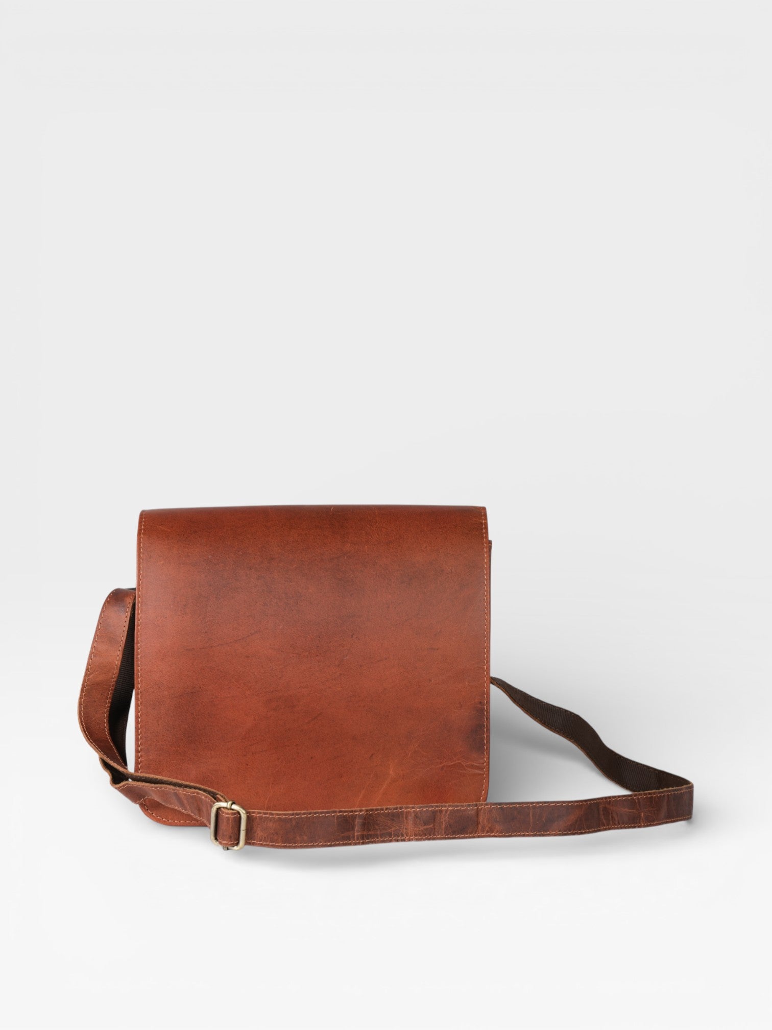 Brown leather bag with a strap on a white background