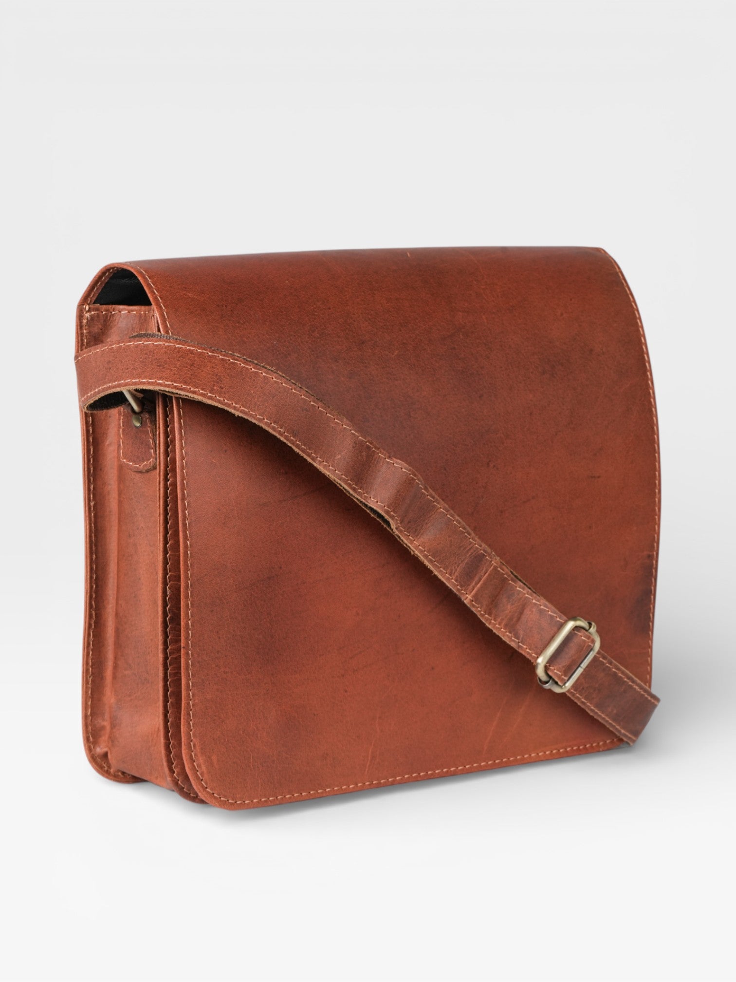 Brown leather messenger bag on a light gray background
