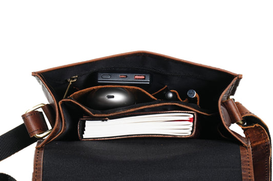 Brown leather bag with a black interior, showing a mouse and notebook.