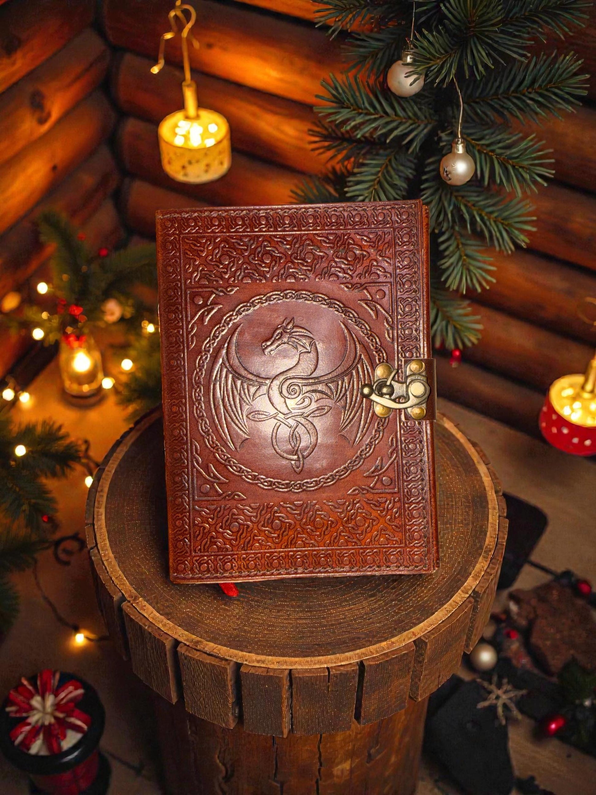Decorative leather-bound book with embossed design on a wooden stand, surrounded by festive decorations.